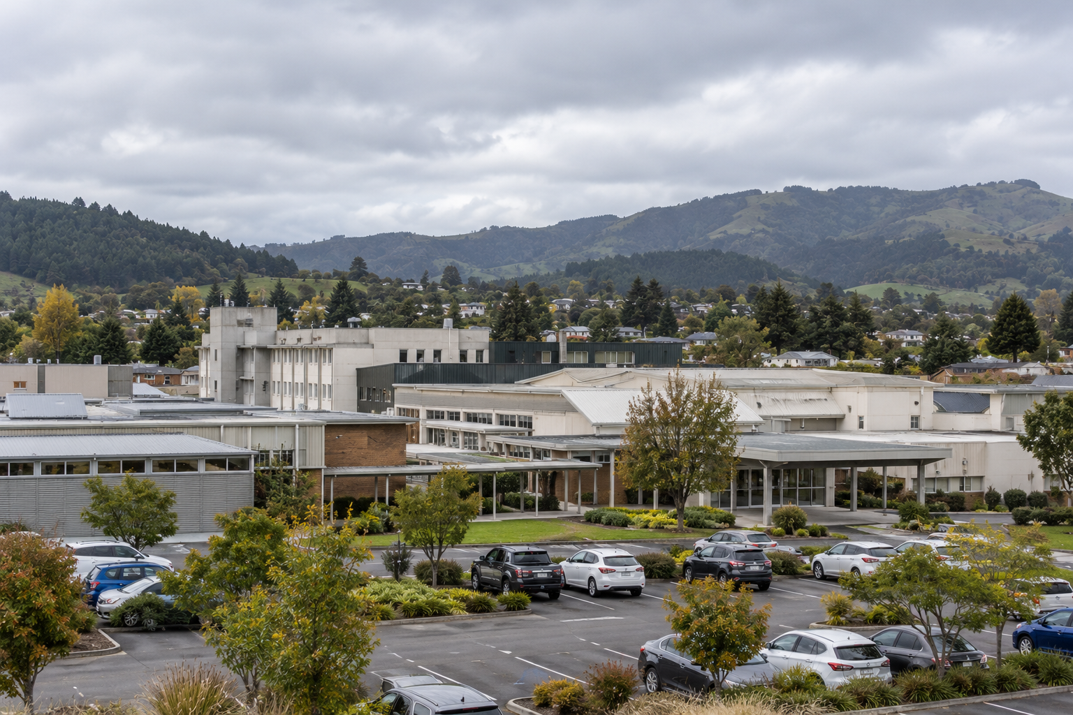 A regional hospital campus beneath bush-covered hills
